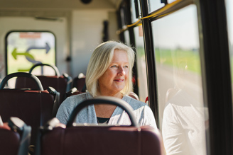 Woman sitting on a bus smiling