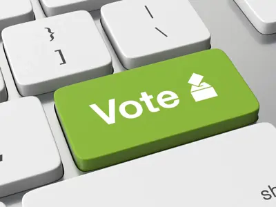 White Computer Keyboard with a green button that reads "Vote"